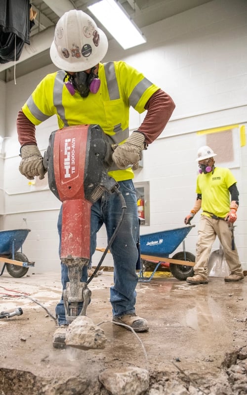 Construction Worker drilling into the street