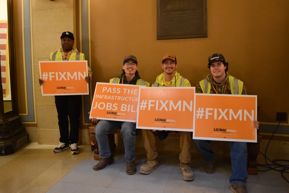 Laborers at rally holding Pass the Infrastructure Jobs Bill signs