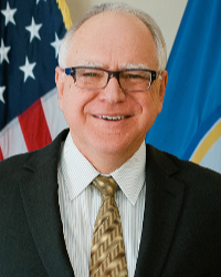 Headshot of Tim Walz in front of the American and Minnesota flag