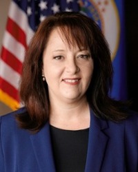 Headshot of Julie Blaha in front of the American Flag